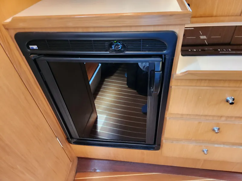 Slide: The Image of 2001 Tiara Yachts 3100 Open interior with compact refrigerator and wooden cabinetry. - 40