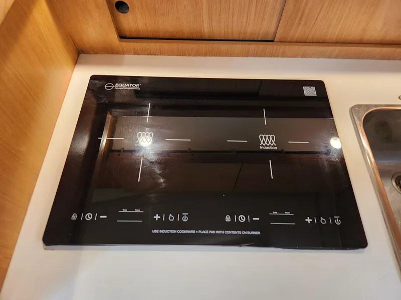 Slide: The Image of Induction cooktop on 2001 Tiara Yachts 3100 Open, featuring sleek black design and control icons. - 41