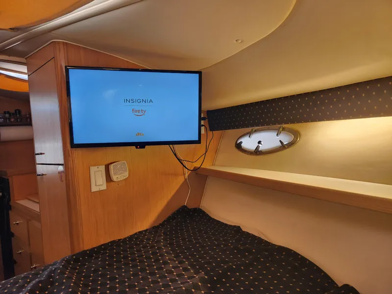 Slide: The Image of 2001 Tiara Yachts 3100 Open cabin interior with TV and cozy bedding. - 47