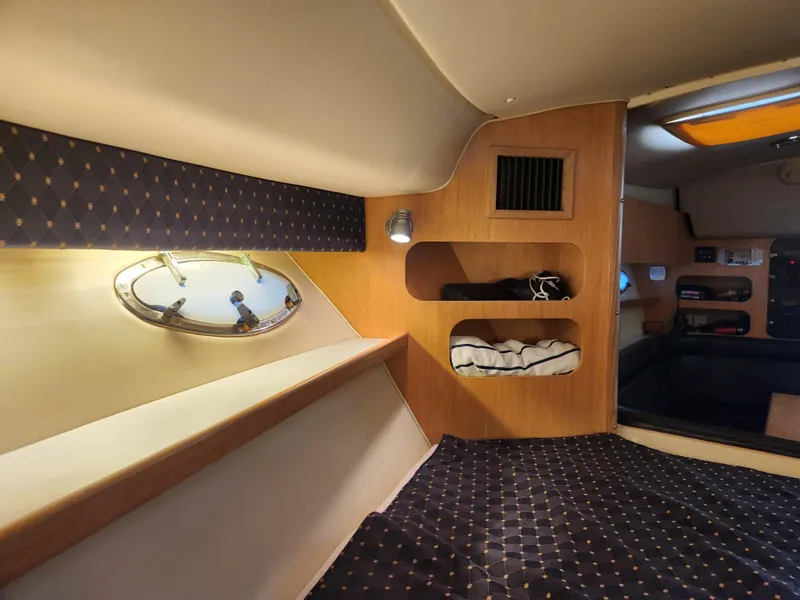 Slide: The Image of 2001 Tiara Yachts 3100 Open cabin interior with cozy bedding and wooden shelving. - 48