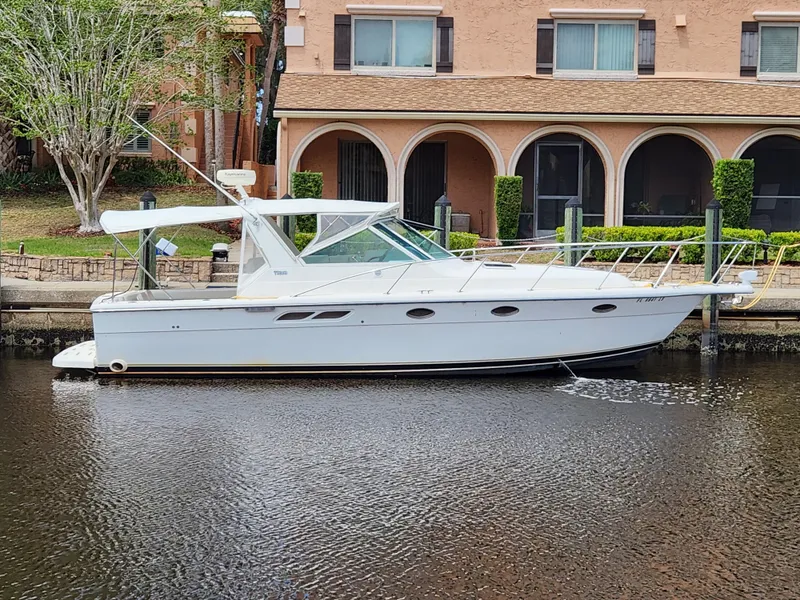 Slide: The Image of 2001 Tiara Yachts 3100 Open docked by a waterfront home. - 6