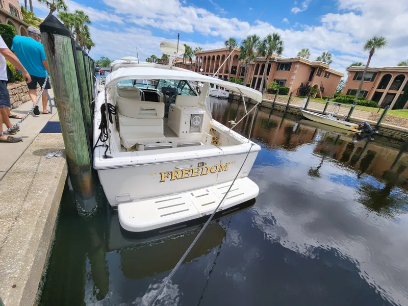 Slide: The Image of 2001 Tiara Yachts 3100 Open docked in a scenic canal setting. - 8