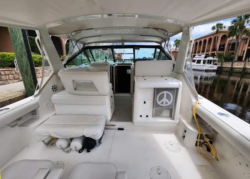 Slide: The Image of 2001 Tiara Yachts 3100 Open interior with white seating and peace symbol decor. - 9