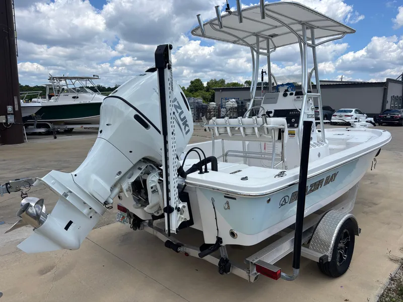 Slide: The Image of 2023 Blazer Bay 2020 boat with Suzuki outboard motor on trailer, parked outdoors. - 4