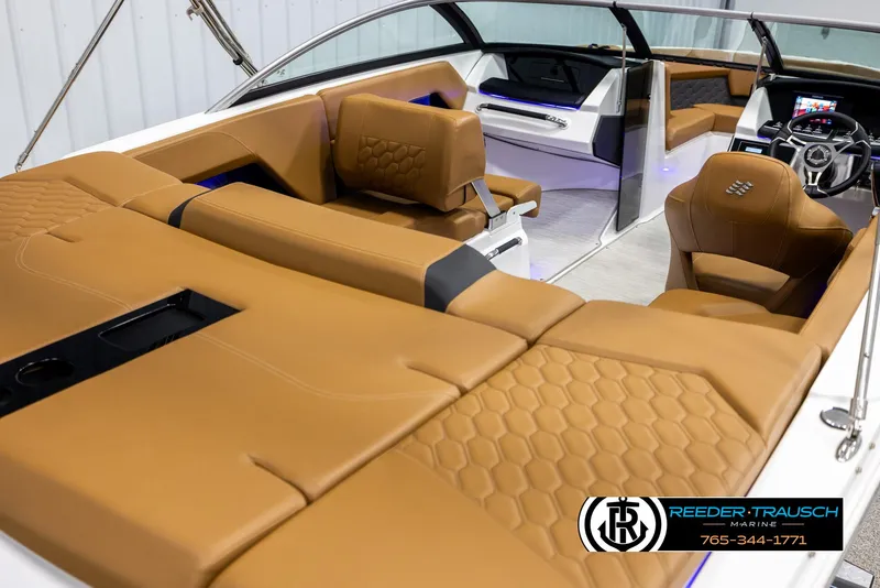 Slide: The Image of 2023 Four Winns H2 boat interior with tan leather seating and modern dashboard. - 12
