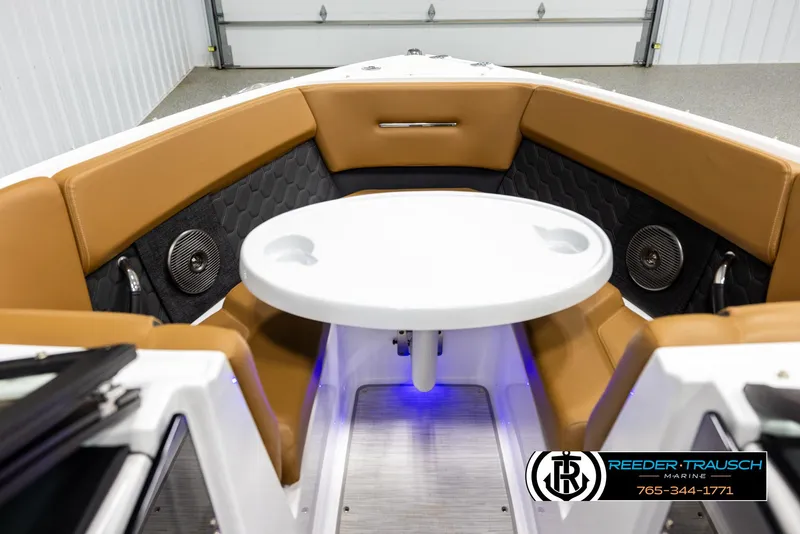 Slide: The Image of 2023 Four Winns H2 boat interior with tan seating and round table. - 17
