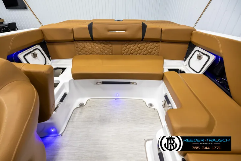 Slide: The Image of 2023 Four Winns H2 boat interior with tan seating and blue accent lighting. - 21