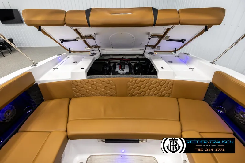 Slide: The Image of 2023 Four Winns H2 boat interior with tan seating and open engine compartment. - 26