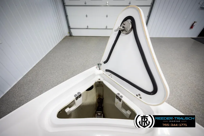 Slide: The Image of 2023 Four Winns H2 boat anchor locker open in a garage setting. - 28