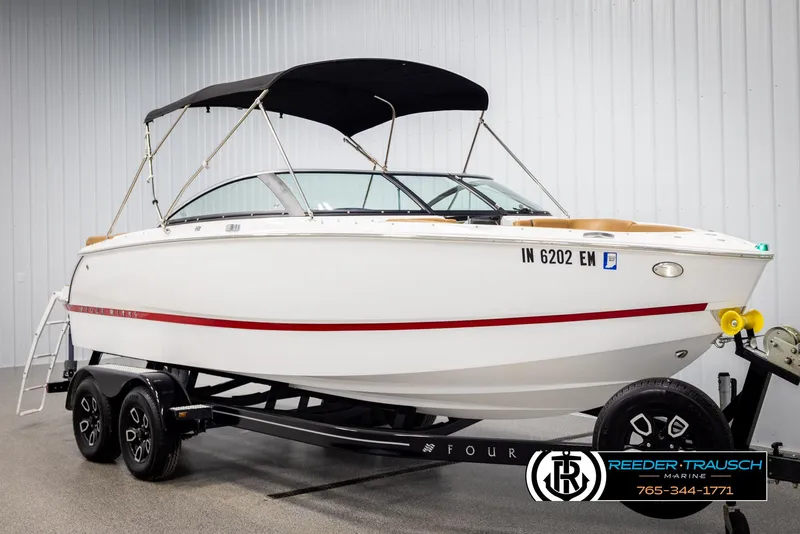 Slide: The Image of 2023 Four Winns H2 boat with black canopy on trailer in showroom. - 3