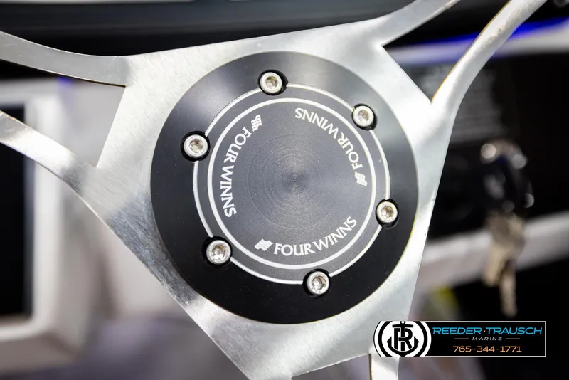 Slide: The Image of Steering wheel of 2023 Four Winns H2 boat, featuring sleek metallic design. - 33