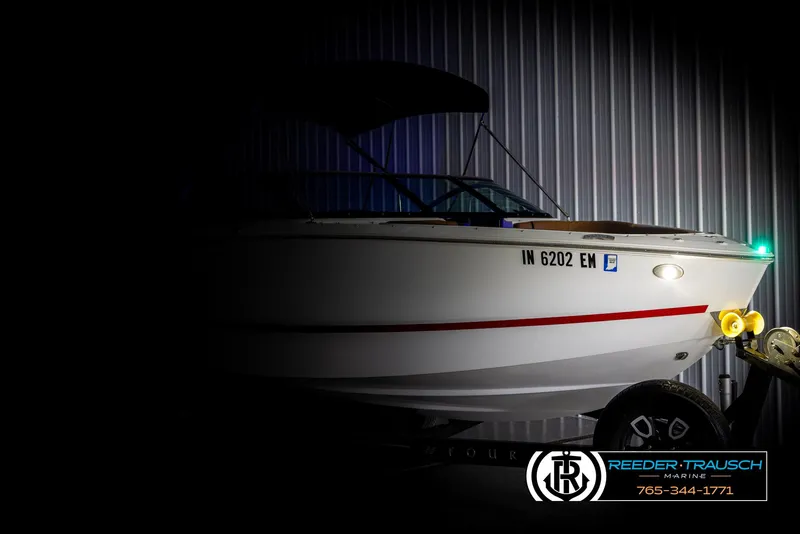 Slide: The Image of 2023 Four Winns H2 boat on trailer in dimly lit showroom. - 4