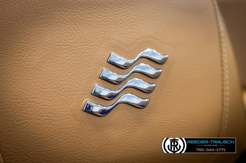Slide: The Image of 2023 Four Winns H2 boat interior with chrome wave emblem on tan leather. - 44