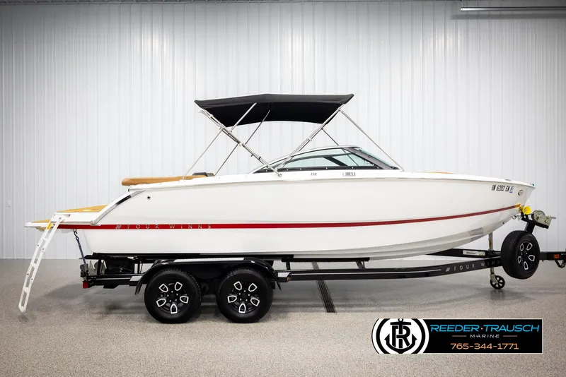 Slide: The Image of 2023 Four Winns H2 boat on trailer, white with red stripe, displayed indoors. - 5