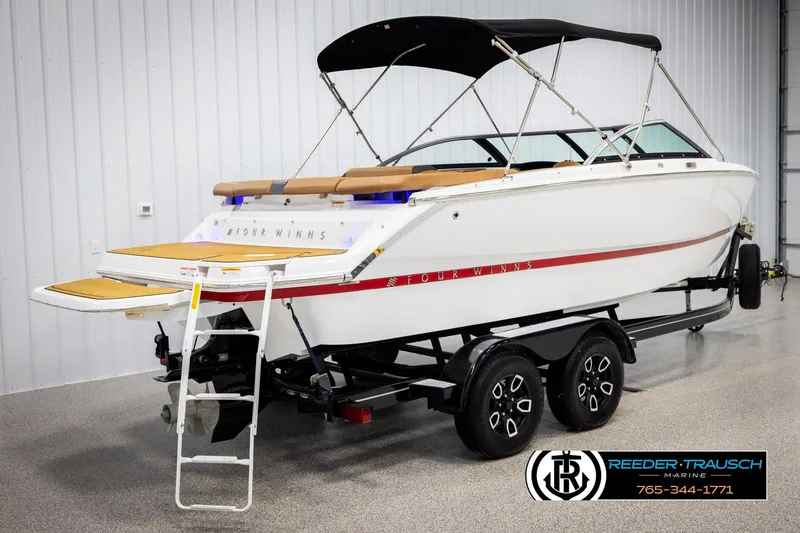 Slide: The Image of 2023 Four Winns H2 boat on trailer, white with red accents, in showroom. - 6