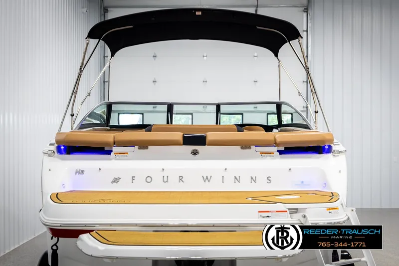 Slide: The Image of 2023 Four Winns H2 boat with canopy, displayed indoors at Reeder-Trausch Marine. - 7