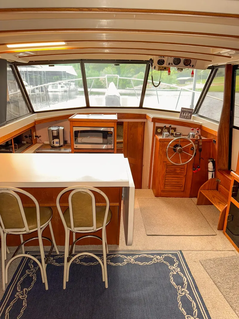 Slide: The Image of 1987 Mainship 40 Aft Cabin interior with helm, bar stools, and kitchen appliances. - 10