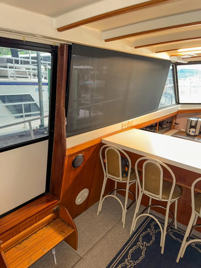 Slide: The Image of 1987 Mainship 40 Aft Cabin interior with bar seating and large windows. - 11