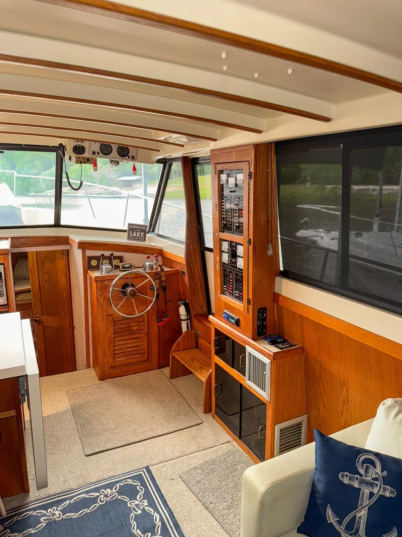 Slide: The Image of 1987 Mainship 40 Aft Cabin interior with helm, wood paneling, and nautical decor. - 12