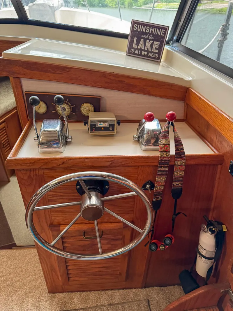 Slide: The Image of 1987 Mainship 40 Aft Cabin helm with steering wheel, controls, and lake-themed decor. - 13