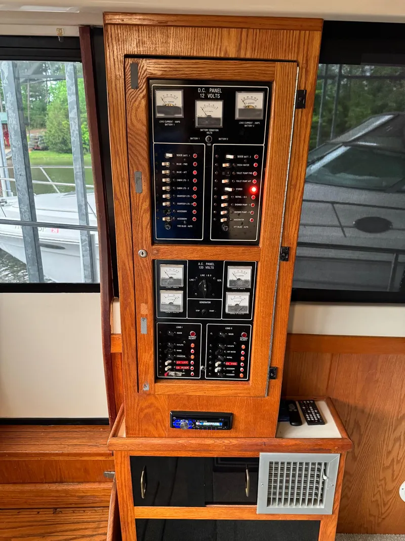 Slide: The Image of Electrical panel inside 1987 Mainship 40 Aft Cabin boat, featuring wood finish and control switches. - 14