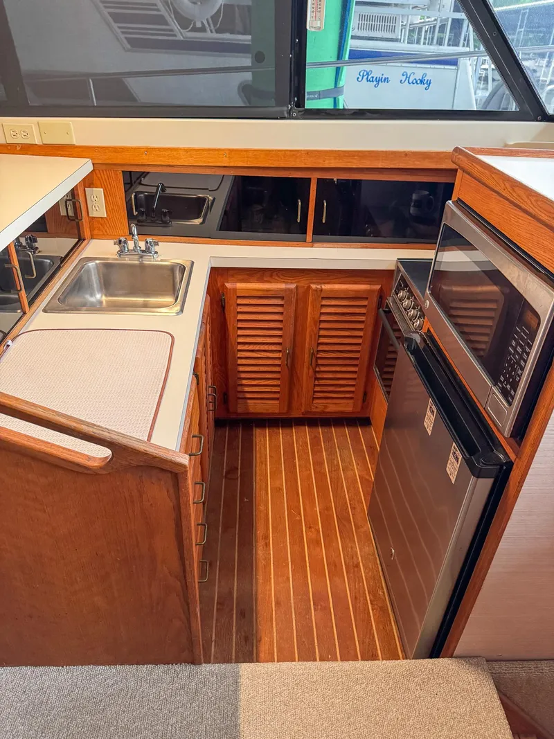 Slide: The Image of 1987 Mainship 40 Aft Cabin kitchen with wood cabinets, sink, and appliances. - 16