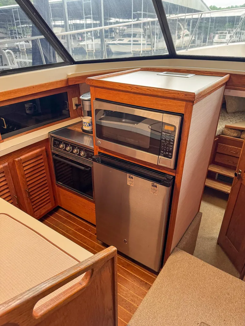 Slide: The Image of 1987 Mainship 40 Aft Cabin kitchen with microwave, stove, and compact fridge. - 17