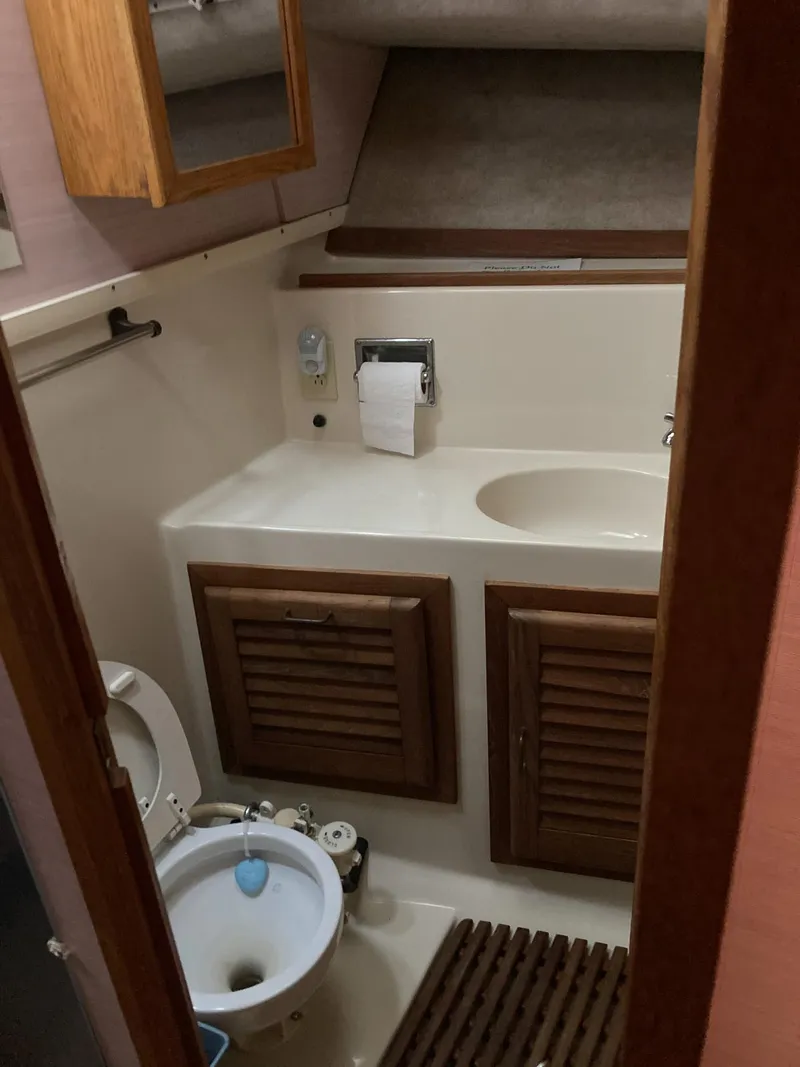 Slide: The Image of 1987 Mainship 40 Aft Cabin bathroom with wooden cabinets and white fixtures. - 20