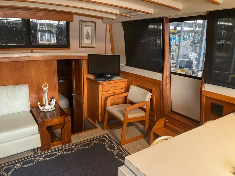 Slide: The Image of 1987 Mainship 40 Aft Cabin interior with wood accents, seating, and TV. - 24