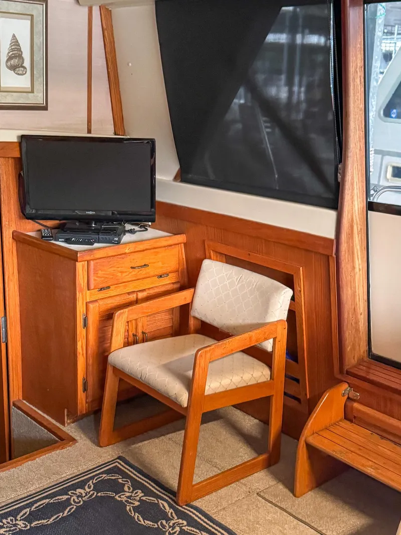 Slide: The Image of 1987 Mainship 40 Aft Cabin interior with wooden furniture and a small TV. - 29