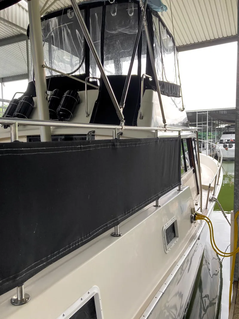 Slide: The Image of 1987 Mainship 40 Aft Cabin boat docked under a covered marina. - 3