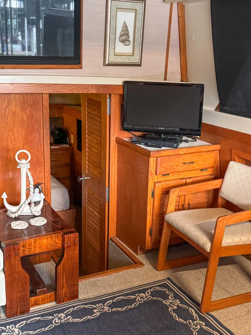 Slide: The Image of 1987 Mainship 40 Aft Cabin interior with wooden furniture, TV, and nautical decor. - 30