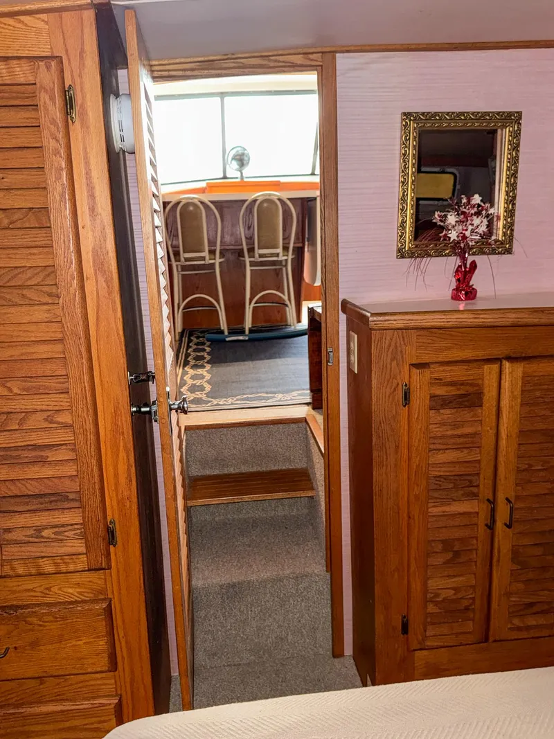 Slide: The Image of 1987 Mainship 40 Aft Cabin interior with wooden cabinets and bar stools. - 32