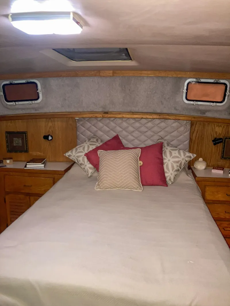 Slide: The Image of 1987 Mainship 40 Aft Cabin bedroom with cozy bedding and wooden cabinetry. - 33