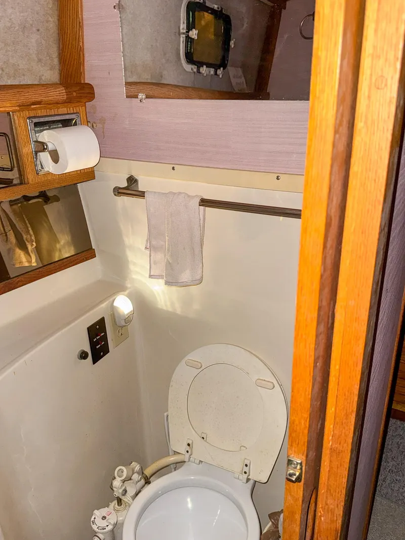 Slide: The Image of 1987 Mainship 40 Aft Cabin bathroom with toilet, towel rack, and wooden accents. - 38