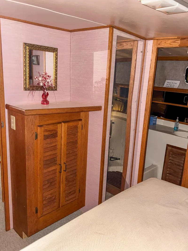 Slide: The Image of 1987 Mainship 40 Aft Cabin interior with wooden cabinet and mirror. - 40