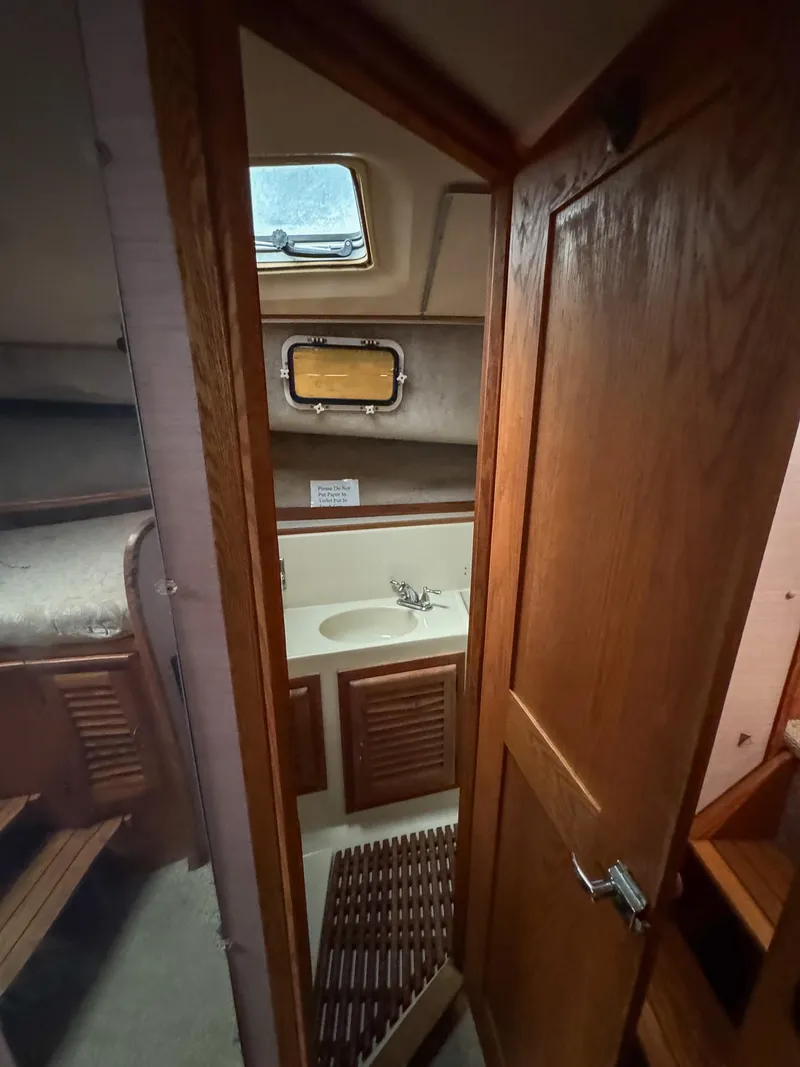 Slide: The Image of 1987 Mainship 40 Aft Cabin bathroom with wooden door and compact sink. - 42