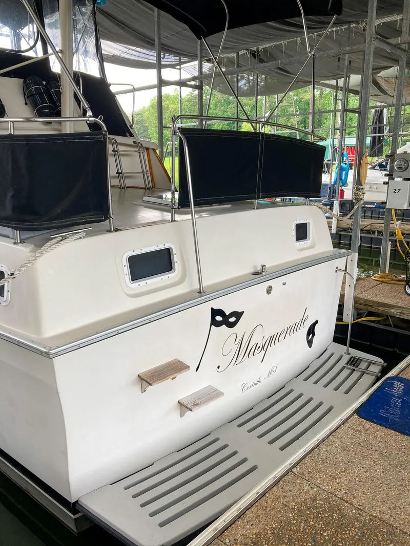Slide: The Image of 1987 Mainship 40 Aft Cabin yacht docked, featuring "Masquerade" name and elegant design. - 6