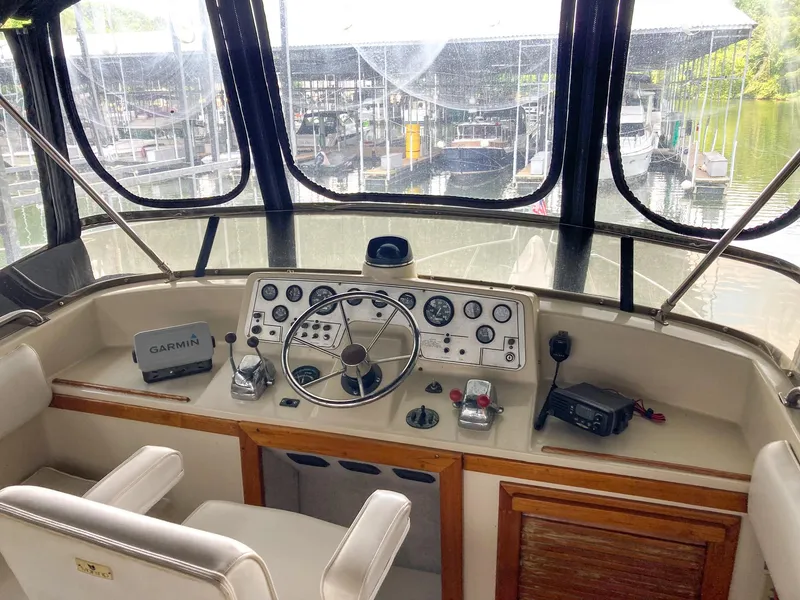 Slide: The Image of 1987 Mainship 40 Aft Cabin helm with steering wheel, controls, and Garmin device. - 8