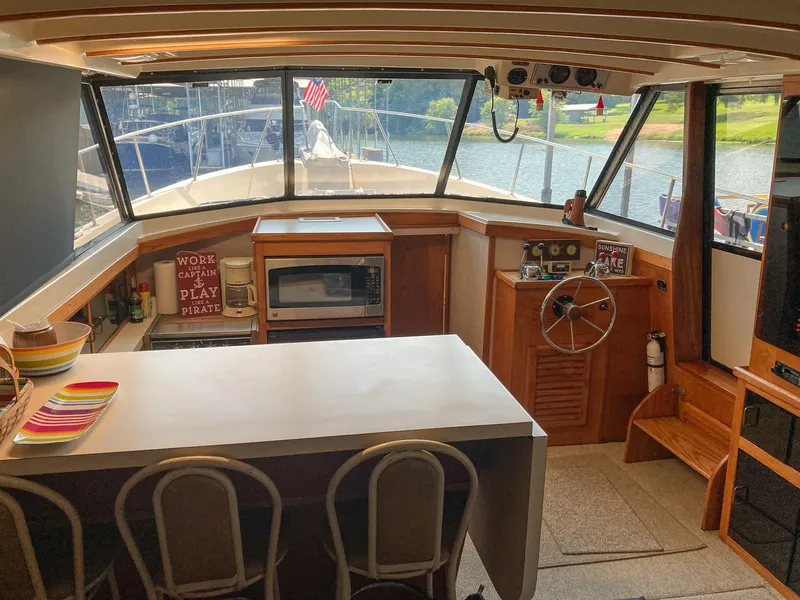 Slide: The Image of Interior of 1987 Mainship 40 Aft Cabin with helm, kitchen, and seating area. - 9