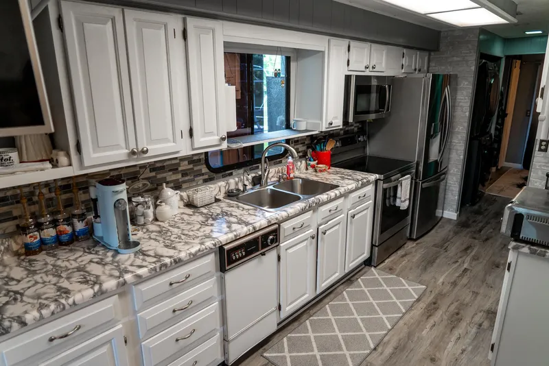 Slide: The Image of Modern kitchen in a 1991 Sumerset 65 x 14 Widebody Houseboat with marble countertops. - 13