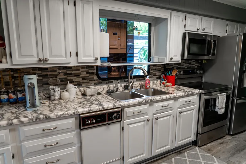 Slide: The Image of Modern kitchen in a 1991 Sumerset 65 x 14 Widebody Houseboat with marble countertops. - 14