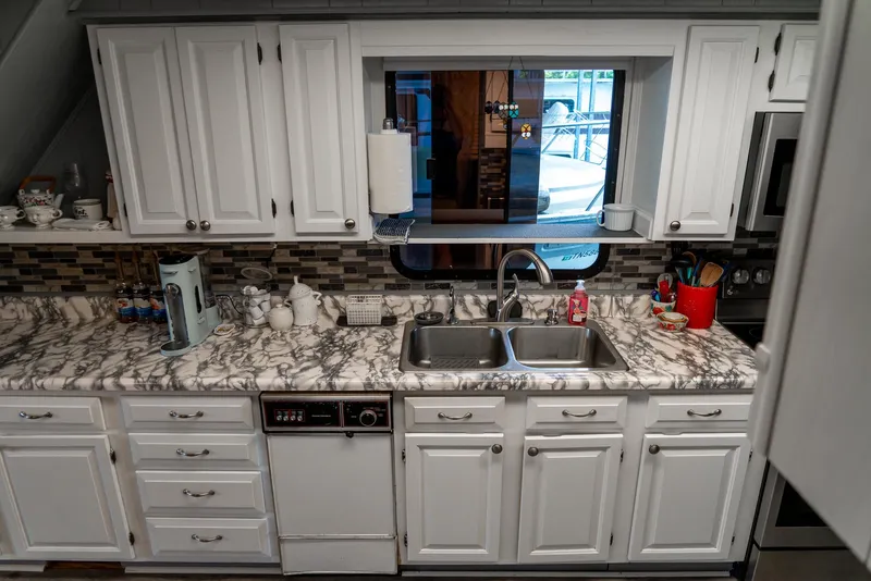Slide: The Image of Kitchen interior of a 1991 Sumerset 65 x 14 Widebody Houseboat with marble countertops. - 16