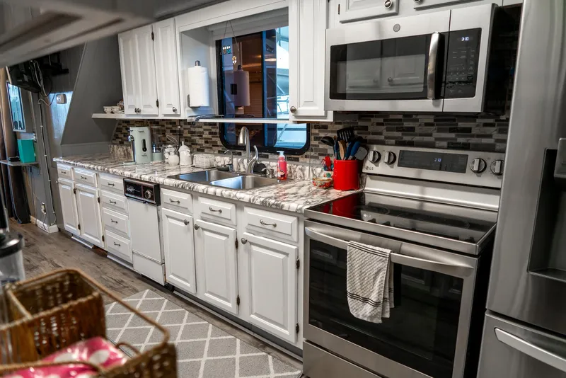 Slide: The Image of Modern kitchen in a 1991 Sumerset 65 x 14 Widebody Houseboat with stainless steel appliances. - 17