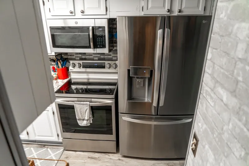 Slide: The Image of Modern kitchen in a 1991 Sumerset 65 x 14 Widebody Houseboat with stainless steel appliances. - 18