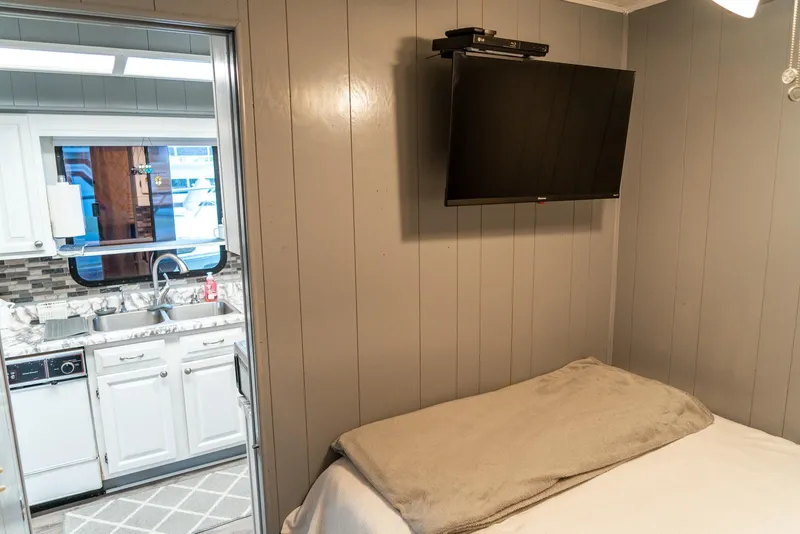 Slide: The Image of Cozy bedroom in 1991 Sumerset houseboat with TV, adjacent to modern kitchen. - 22