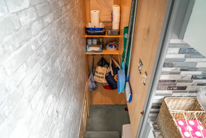 Slide: The Image of Storage area in a 1991 Sumerset 65 x 14 Widebody Houseboat with shelves and cleaning supplies. - 23