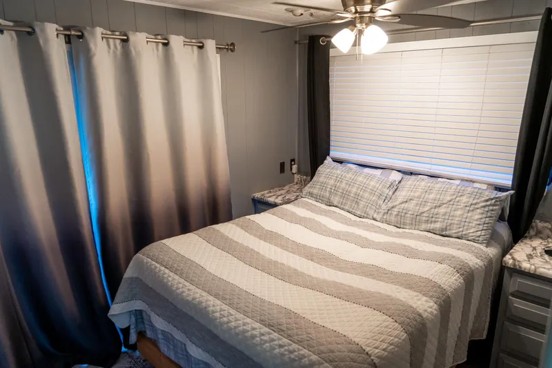 Slide: The Image of Cozy bedroom in 1991 Sumerset 65 x 14 Widebody Houseboat with striped bedding and modern decor. - 25