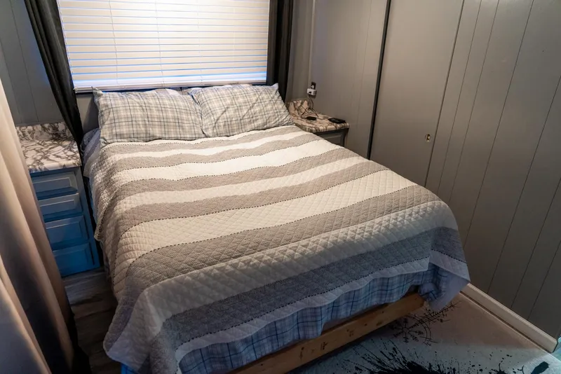 Slide: The Image of Cozy bedroom in 1991 Sumerset 65 x 14 Widebody Houseboat with striped bedding. - 27