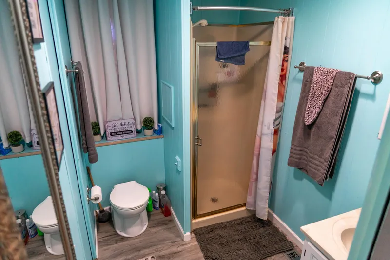 Slide: The Image of Bathroom interior of 1991 Sumerset 65 x 14 Widebody Houseboat, featuring shower and toilet. - 29